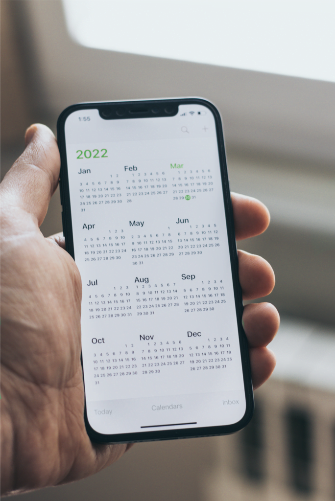 homem segurando um celular mostrando o calendário de 2022