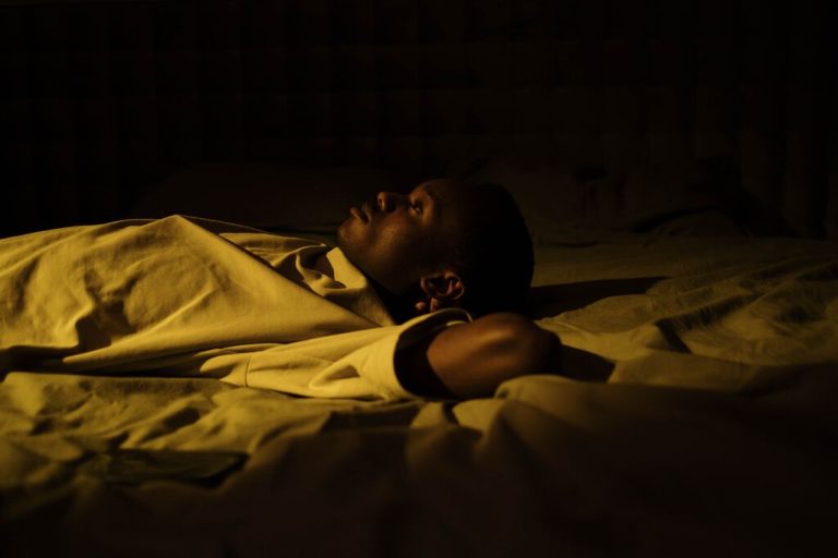 homem deitado na cama acordado